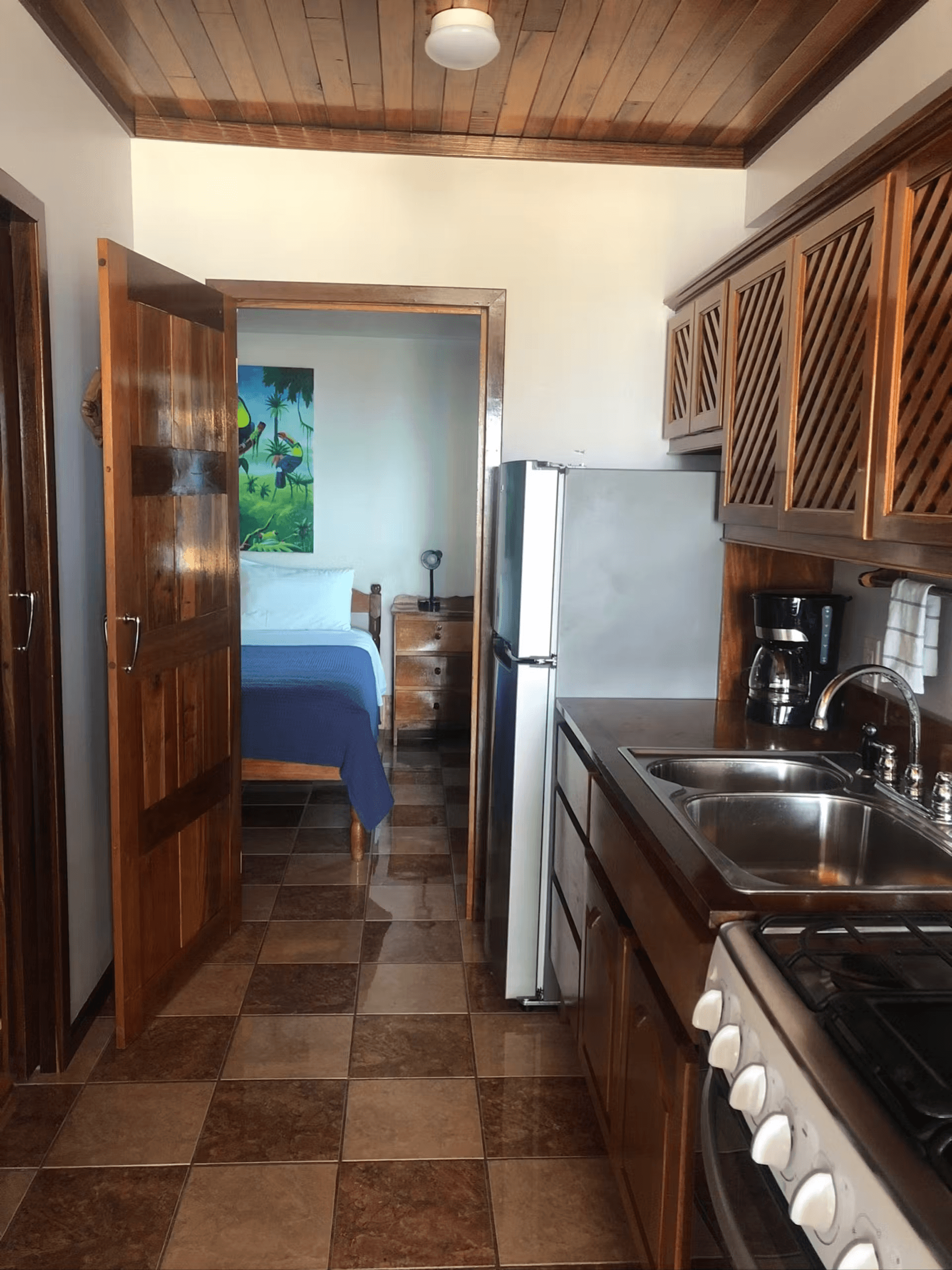 View of bedroom from kitchen through beautifully finished hardwood door