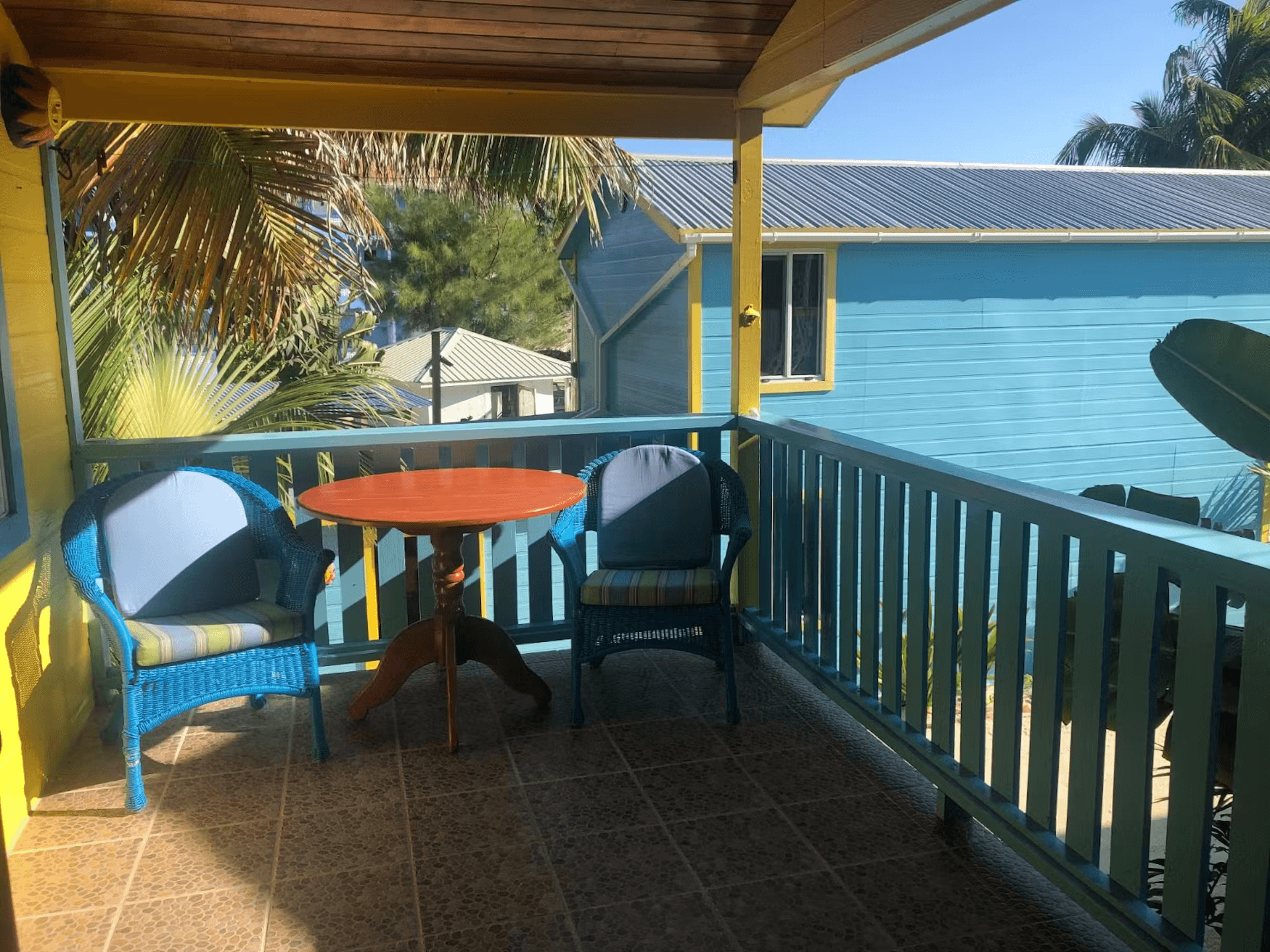 Balcony with two cushioned chairs and a round table between them