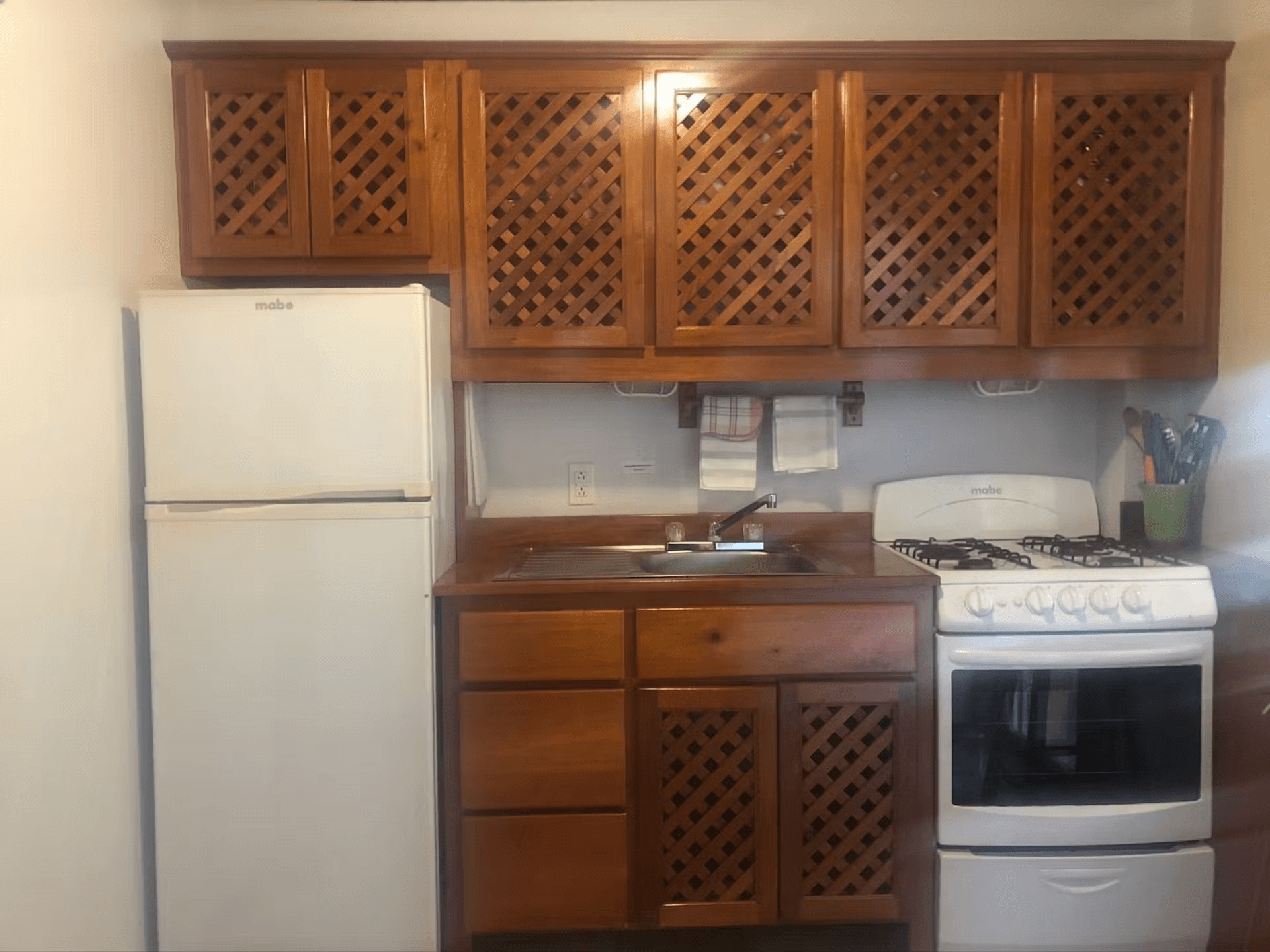 Kitchen with richly finished wood cabinets, refrigerator, sink, and stove