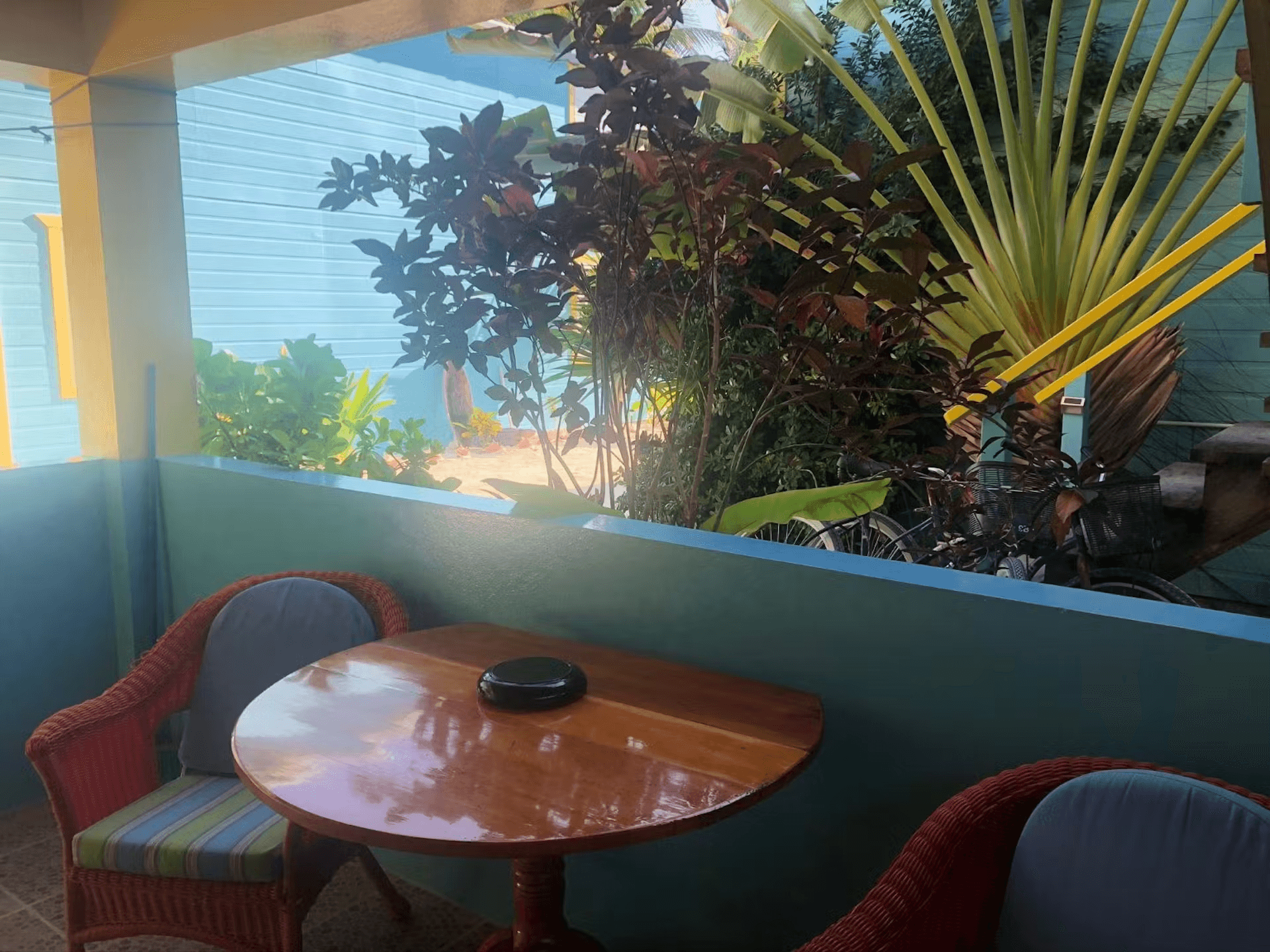 Patio with two chairs and a table overlooking tropical foliage and ocean views