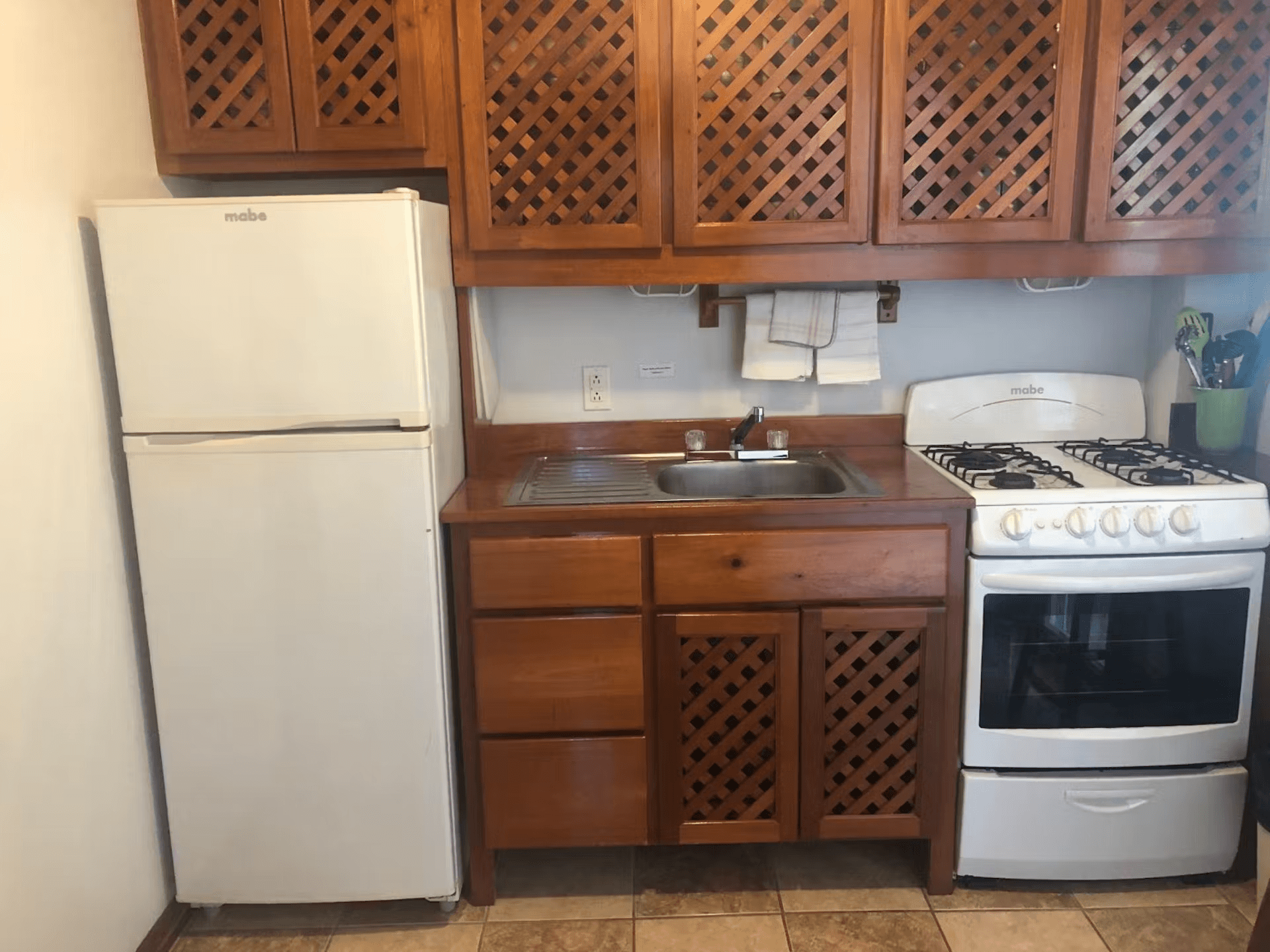 Kitchen with beautifully finished hardwood cabinets, refrigerator, sink, and stove