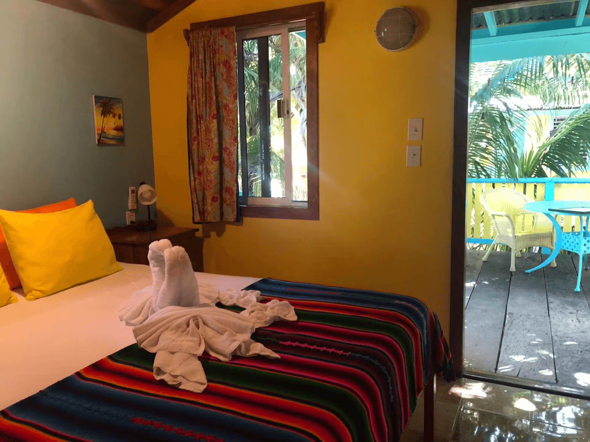 Bedroom with queen bed, striped bedding, and doorway leading to balcony