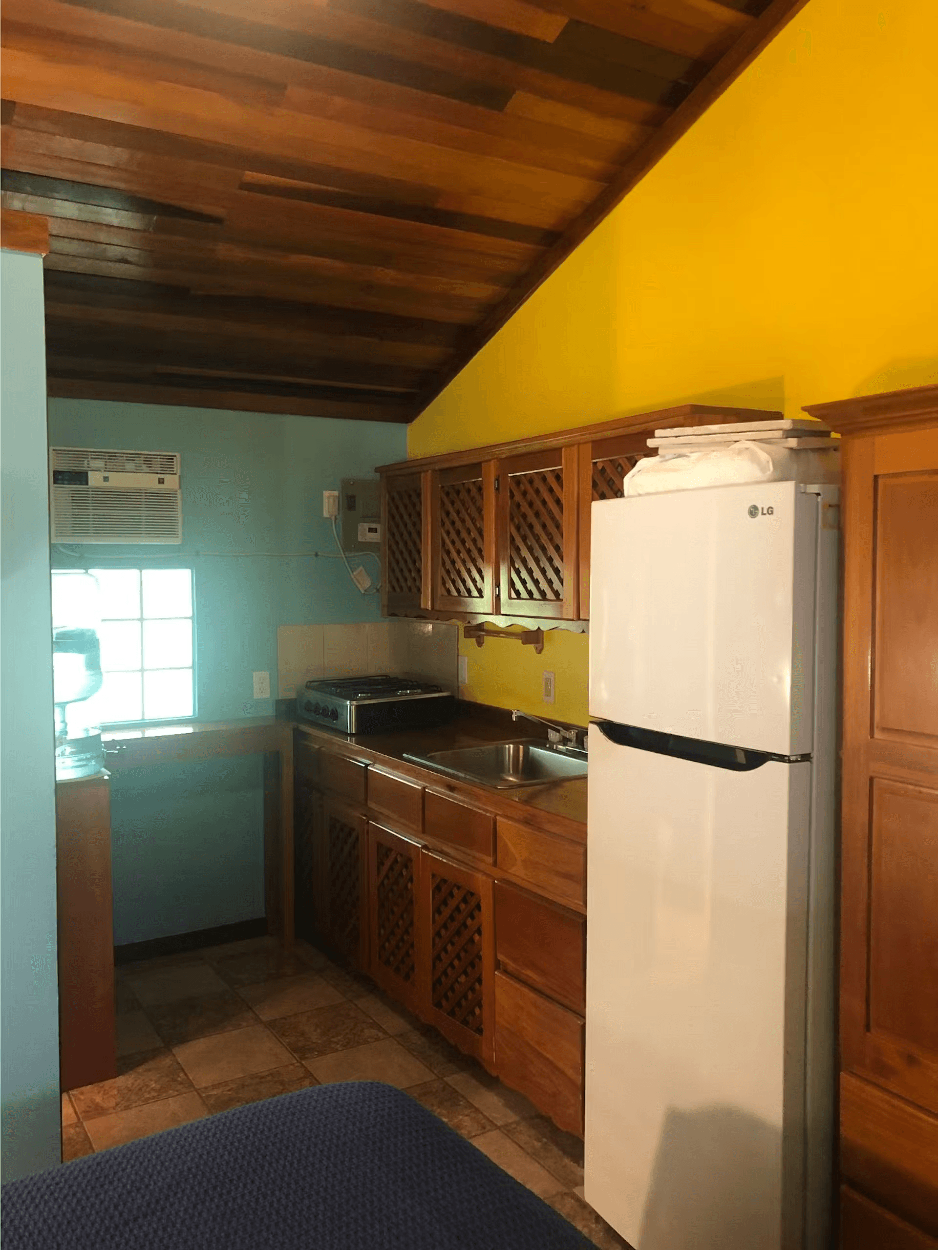 Kitchen with beautifully finished wood cabinets and vaulted ceilings, refrigerator, and sink