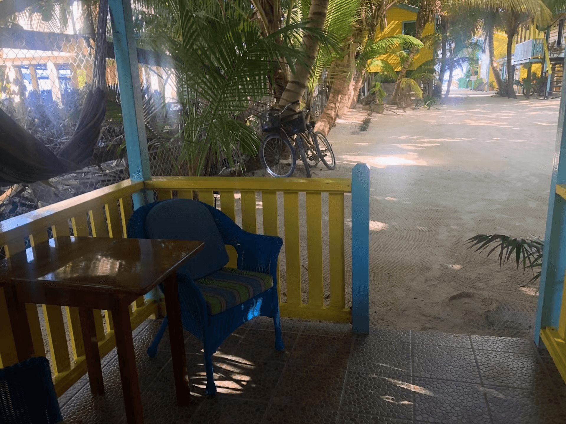 Ground-level patio with chair and table just a step away from sand