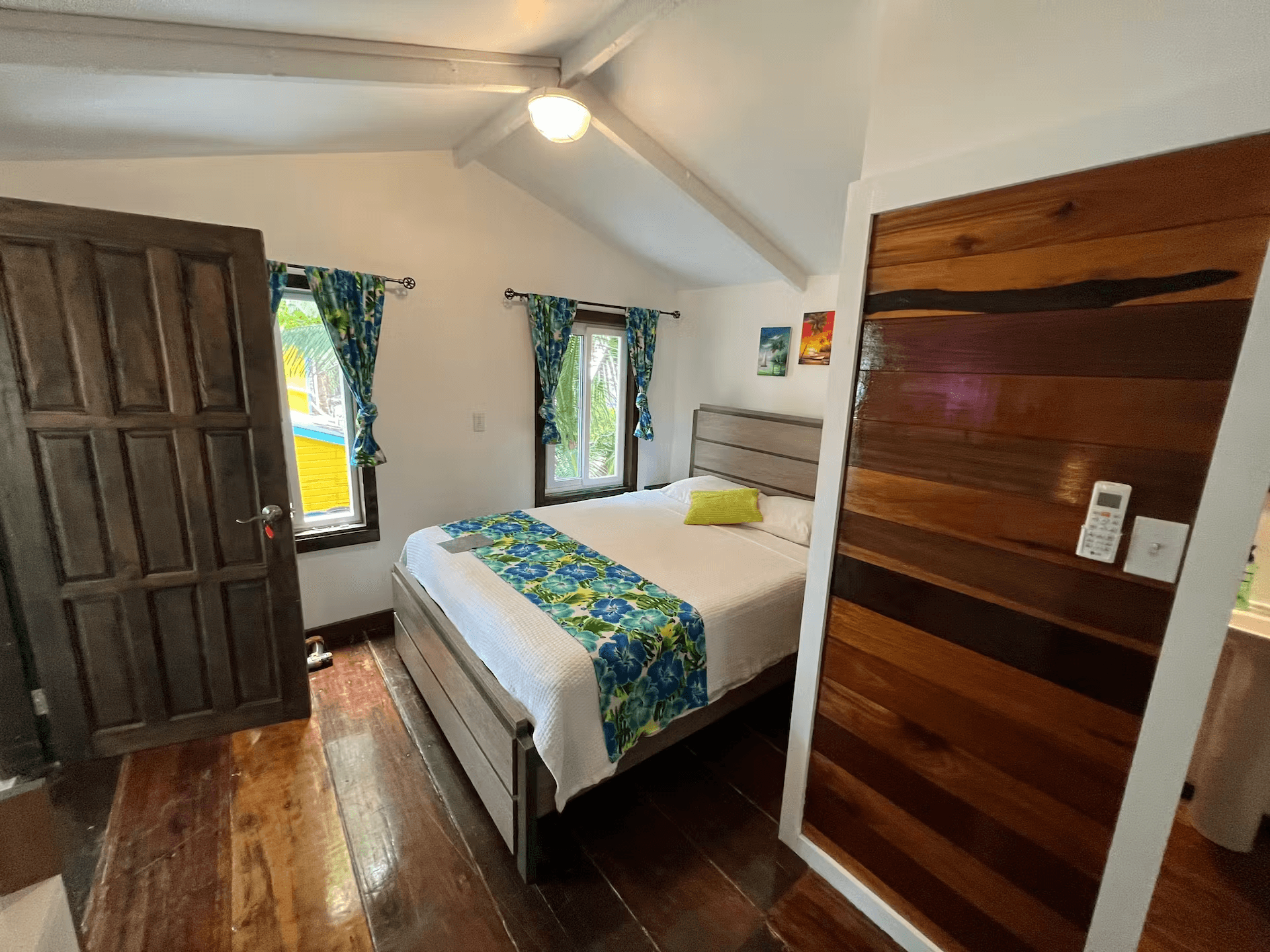 Bedroom with queen bed, vaulted ceilings, and hardwood floors