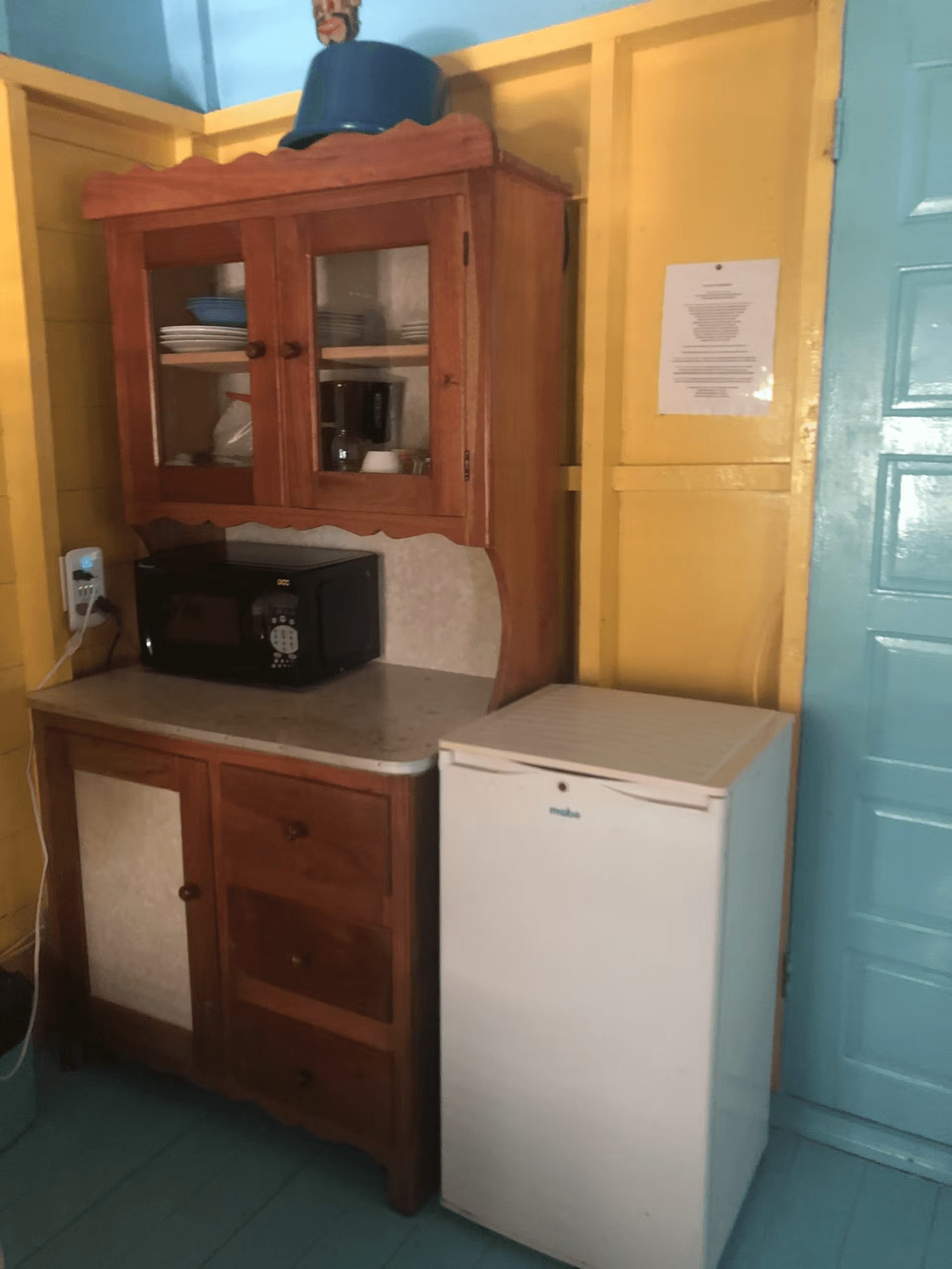 Kitchen with wooden hutch, microwave, and small fridge
