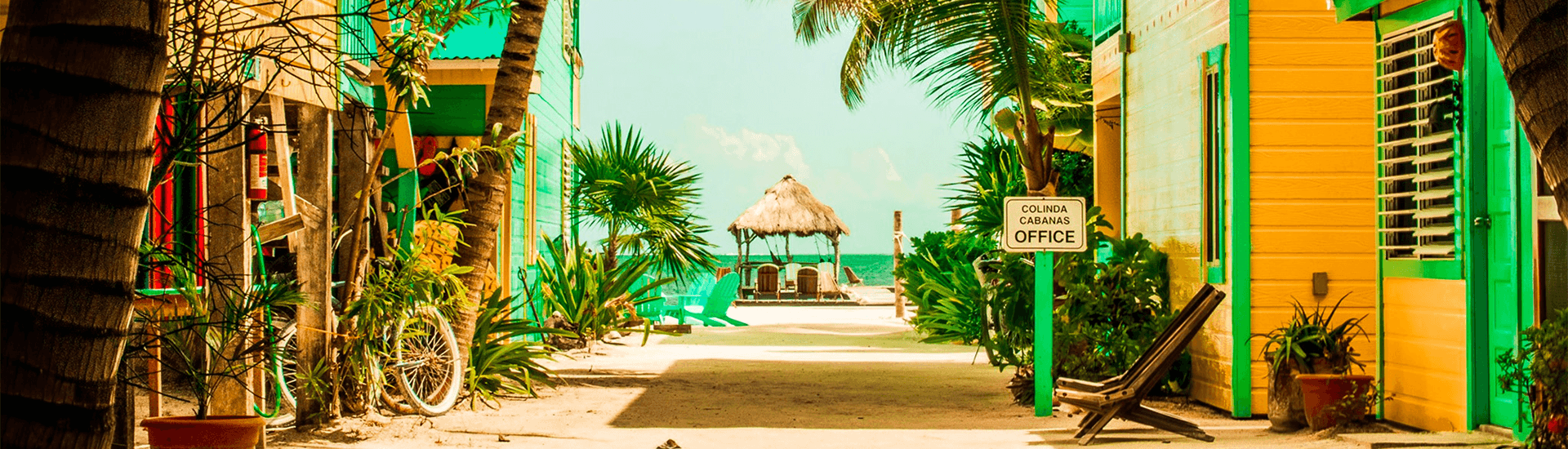 View of a pathway that takes you to the beach and cabanas. On the left and right of the path are buildings.