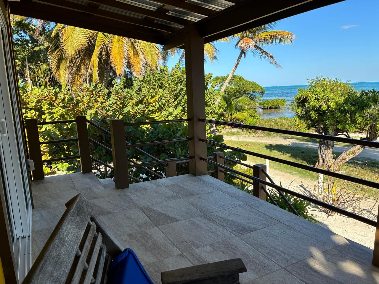 A serene outdoor patio overlooking tropical vegetation and a peaceful ocean view.